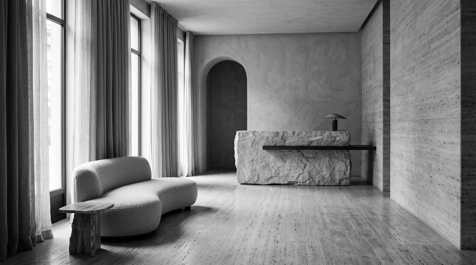 Hotel lobby with a sculptural sofa and a stone reception desk